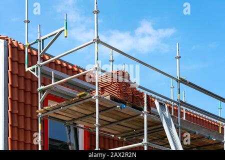 Dacheindeckung. Gerüst an einer Ziegelfassade verkleidetes Haus. Leerzeichen für Text. Stockfoto