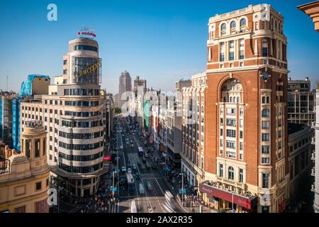 Landmark-Gebäude und Verkehr auf der Gran Via Straße im Zentrum von Madrid, der Hauptstadt und größten Stadt Spaniens. Stockfoto