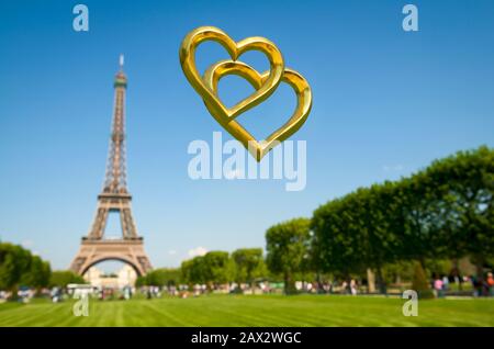 Zwei goldene Herzen schweben draußen über einem sonnigen Blick auf den Eiffelturm in Paris, Frankreich Stockfoto