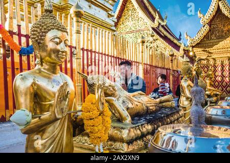 Thailändisch-buddhistische Anhänger wandern um die wichtigsten goldenen Chedi im Wat Phra That Doi Suthep Tempel in Chiang Mai, Thailand. Stockfoto