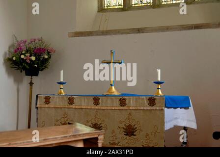 Kreuz und zwei Kerzen auf dem Altar, St. Pancras Kirche, Widecome im Moor, Devon, England Stockfoto