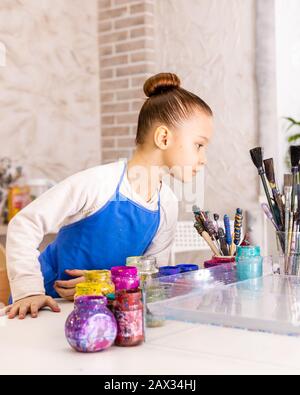 Mädchen 6 Jahre alt in einem Kunststudio. Meisterklasse im Atelier Ebru - die Kunst des "Malens auf dem Wasser". Stockfoto