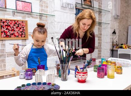 Die Lehrerin zeigt die Techniken des Mädchens, um Gemälde zu erstellen. Meisterklasse im Atelier Ebru - die Kunst des "Malens auf dem Wasser". Stockfoto