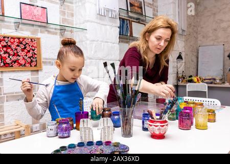 Die Lehrerin zeigt die Techniken des Mädchens, um Gemälde zu erstellen. Meisterklasse im Atelier Ebru - die Kunst des "Malens auf dem Wasser". Stockfoto