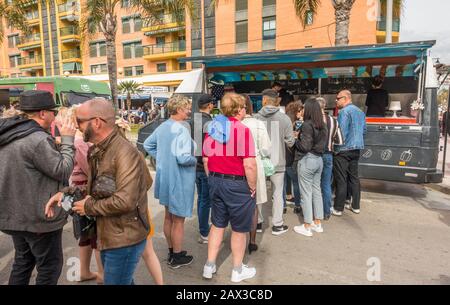 Leute, die sich in einem Lebensmittel-Lastwagen mit Hamburger auf der Straße auskleiden. Spanien. Stockfoto