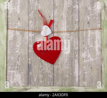 Rotes Filzherz, das an einem braunen Seil hängt, Kulisse für den Valentinstag Stockfoto