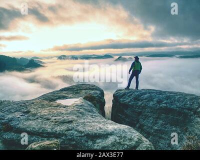 Einsame männliche Wanderer blickt über die hohen Berge und das Tal. Sturm schwere Wolken über den hohen Gipfeln, wie Sie denkt über die Aussicht auf das Tal. Stockfoto