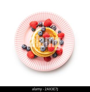 Süße hausgemachte Pfannkuchen mit Blaubeeren und Himbeeren isoliert auf weißem Hintergrund. Stockfoto