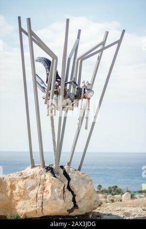 Vertikale Aufnahme einer Metallkonstruktion, die einer Roboterspinne ähnelt Am Strand Stockfoto