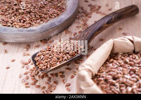 Leinsamen im Behälter und Löffel auf dem Tisch. Stockfoto
