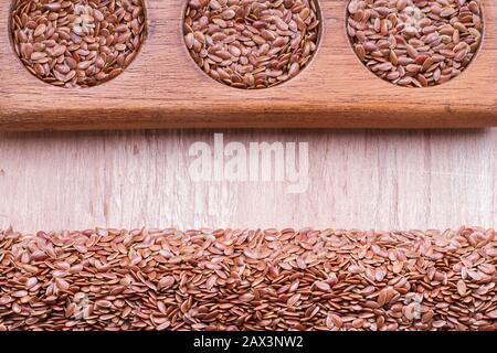 Leinsamen im Behälter und Löffel auf dem Tisch. Stockfoto