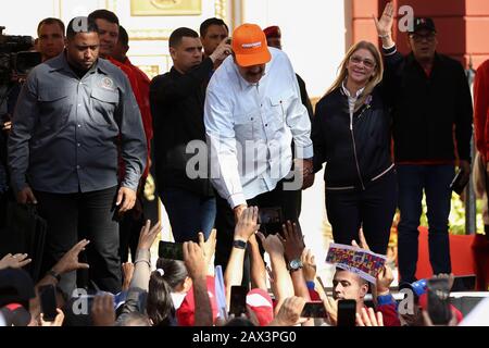 10. Februar 2020, Venezuela, Caracas: Nicolas Maduro (M.), Präsident von Venezuela, trägt eine Kappe der venezolanischen Fluggesellschaft Conviasa und Wellen mit seiner Frau Cilia Flores (r) zu den Anhängern in einem Protest gegen die Ankündigung neuer US-Sanktionen gegen die venezolanische Fluggesellschaft. "Die staatliche Fluggesellschaft Conviasa unterstützt das illegale Regime Maduros durch Flüge von Beamten seines korrupten Regimes auf der ganzen Welt", zitierte das US-Finanzministerium Finanzminister Mnukhin in der Ankündigung. Vor Anhängern konterte das venezolanische Staatsoberhaupt: "Wir werden den Internationalen Gerichtshof von Justi anrufen Stockfoto