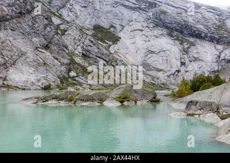 Norwegen Berge Landschaft Blick in der Nähe des Sees mit azurblauem Wasser, Felsen, Gletscher, Schnee. Bewölkte Tages-Tracking-Reise nach Nigardsbreen in Jostedalsbreen Nati Stockfoto