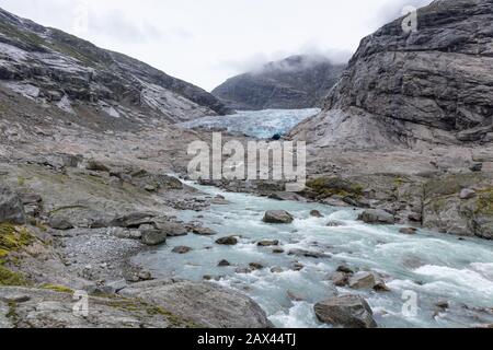 Bewölkte Tagesausfahrt nach Nigardsbreen im Jostedalsbreen-Nationalpark. Blick auf die Landschaft der Berge Norwegens mit blauem Fluss, Eis, Felsen, Gletscher, Stockfoto