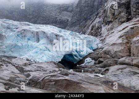 Bewölkte Tagesausfahrt nach Nigardsbreen im Jostedalsbreen-Nationalpark. Blick auf die Landschaft der Berge Norwegens mit blauem Eis, Felsen, Gletscher und Schnee. Klima Stockfoto