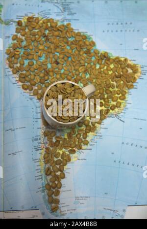 Nahaufnahme einer Tasse voller Rohkaffebohnen auf einer Karte Südamerikas Stockfoto