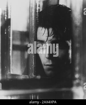 Der französische Filmschauspieler GERARD PHILIPE (* 1922 in LE DIABLE AU CORPS ("Teufel im Fleisch - Il diavolo in Corpo") von Claude Autant-Lara Aus einem Roman von Raymond Radiguet   FILM - KINO - francese - attore - FILM - tristezza - gelosia - Eifersucht - geloso - eifersüchtig - traurig - betrübt - düster - beängstigend - Liebhaber - innamorato - amore - Liebe - finestra - Fenster - Voyeur - curioso - neugierig - curiosità - Neugier - Spion - Regen - Pioggie --- Archivio GBB Stockfoto