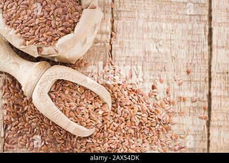 Leinsamen im Behälter und Löffel auf dem Tisch. Stockfoto