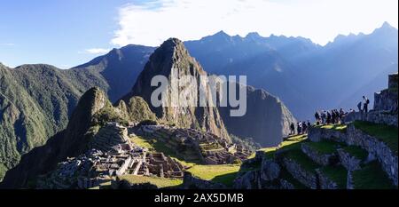 Licht scheint auf berühmte Ruinen in Peru mit vielen Touristen erkunden. Stockfoto