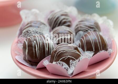 Nahaufnahme des luxuriösen Haufens von Schokoladenkäuzen. Verschiedene Schokoladenwürfel. Dunkle Schokoladenkugeln für Jubiläum oder Hochzeitsfeier. Lecker, braten Stockfoto