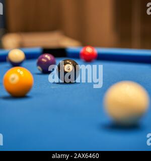 Pool/Billard/Snooker. Poolbälle auf dem Billardtisch mit Schwerpunkt auf dem Achtball. Stockfoto