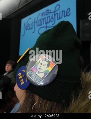 Milford, New Hampshire, USA. Februar 2020. Ein Pete Buttigieg-Anhänger trägt Knöpfe mit dem Kandidaten, der vor einer Regenbogenfahne bei der "Get Out the Vote"-Kundgebung in Milford, New Hampshire abgebildet ist. Credit: Sue Dorfman/ZUMA Wire/Alamy Live News Stockfoto