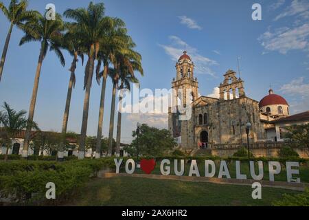 Die Kirche Parroquia Santuario Nuestra Señora de Guadalupe und der palmenplatz von Guadalupe, Santander, Kolumbien Stockfoto