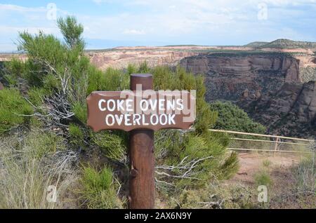 Fruita, COLORADO - 23. JUNI 2016: Cola Ovens Overlook Sign Along Rim Rock Drive im Colorado National Monument mit Book Cliffs in the Distance Stockfoto