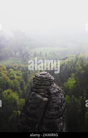 Über dem Nebelwald in Sachsen stehender Turm aus Sandstein Stockfoto