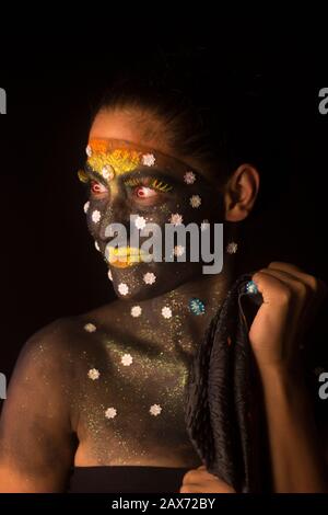 Modeporträt eines dunkelhäutigen Mädchens mit Farb-Make-up. Schönheitsgesicht, Heckenoptiok, seitwärts blickend Stockfoto