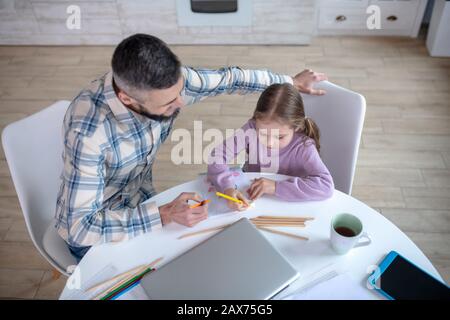 Vater mit Tochter am Tisch in der Küche malen. Stockfoto