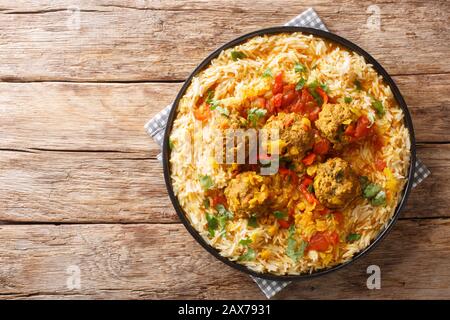 Kofta Chalao Rezept für afghanische Fleischbällchen in würziger Soße mit gelben Erbsen serviert mit Basmati-Reis in einer Platte auf dem Tisch. Horizontal oben vie Stockfoto