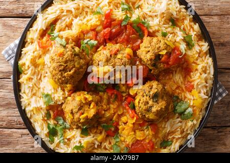 Kofta Chalao Hat Fleischbällchen in würziger Soße mit gelben Erbsen zubereitet, die mit Basmati-Reis in einem Teller auf dem Tisch serviert wurden. Horizontale Draufsicht von Abo Stockfoto