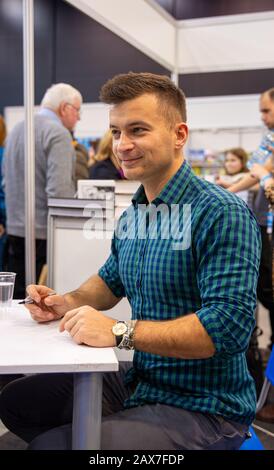 Katowice, Polen - 6. Bis 8. Dezember 2019: Jakub Malecki, polnischer Schriftsteller schreibt Bücher während der Schlesischen Buchmesse 2019 in Katowice auf der Internationalen Congre Stockfoto