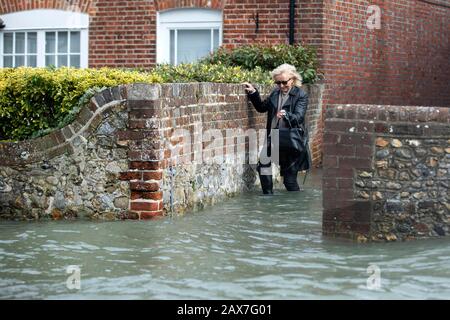 Bosham, West Sussex. Februar 2020. Wetter in Großbritannien: Ein Einwohner weht durch Flutwasser, während die Gezeiten im zuge des Sturms Ciara steigen und das Dorf Bosham, West Sussex, Großbritannien am Montag, 10. Februar 2020 überschwemmen. Viele Orte in Großbritannien bleiben mit gelben Wetterwarnungen, während die Storm-Ciara-Wetterfront weitergeht. Foto: Luke MacGregor Credit: Luke MacGregor/Alamy Live News Stockfoto