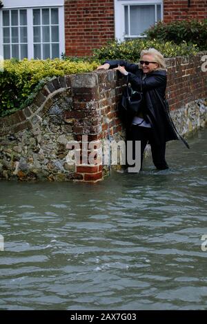 Bosham, West Sussex. Februar 2020. Wetter in Großbritannien: Ein Einwohner weht durch Flutwasser, während die Gezeiten im zuge des Sturms Ciara steigen und das Dorf Bosham, West Sussex, Großbritannien am Montag, 10. Februar 2020 überschwemmen. Viele Orte in Großbritannien bleiben mit gelben Wetterwarnungen, während die Storm-Ciara-Wetterfront weitergeht. Foto: Luke MacGregor Credit: Luke MacGregor/Alamy Live News Stockfoto