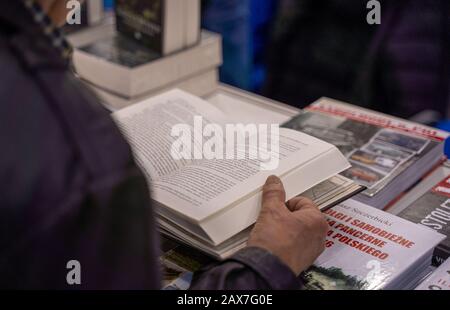 Katowice, Polen - 6. Bis 8. Dezember 2019: Männer, die das Buch auf historischen Büchern durchsuchen, stehen 2019 während der Schlesischen Buchmesse in Katowice Stockfoto