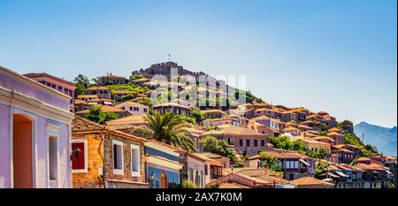 Die griechische Stadt Molyvos (Mithymna) und ein beeindruckendes Fort oder eine beeindruckende Burg auf dem Hügel im Hintergrund. Stockfoto