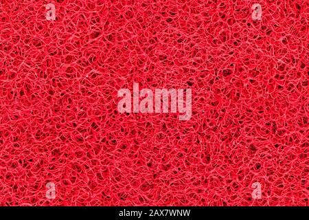 Nahdetails leuchtend rote Kunststoff-Fußmatte nahtlose Textur. Neutrale abstrakte Hintergrundoberfläche Stockfoto