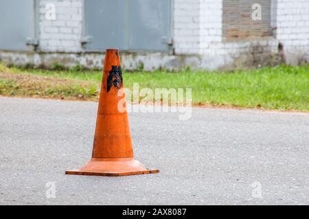 Orangefarbener Kegel auf der Straße, Straßenarbeiten, mit Kopierraum Stockfoto