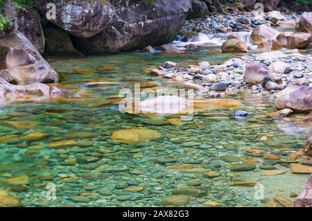 Kristallklares Flusswasser, das über Felsen fließt. Hintergrund der Natur Stockfoto