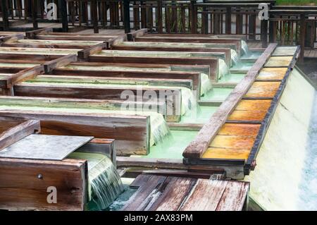 Yubatake Hot-Spring-Infrastruktur mit Holzkisten mit Mineralwasser. Kusatsu, Japan Stockfoto