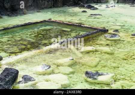 Mineralsedimente von Schwefel auf dem Boden von Yubatake Onsen in Kusatsu, Japan. Stockfoto