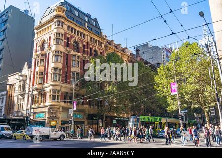 Melbourne, Australien - 03. April 2017: Melbourne City Life. Menschen, die die Collins Street mit dem Verkehr von Autos und Straßenbahn überqueren Stockfoto