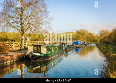 Eine ruhige sonnige Landschaft Anfang Januar, die den Kennet- und Avon-Kanal und schmale Boote zeigt, die auf Honeystreet in der Vale von Pewsey in Wiltshire England in Großbritannien gefestigt sind Stockfoto