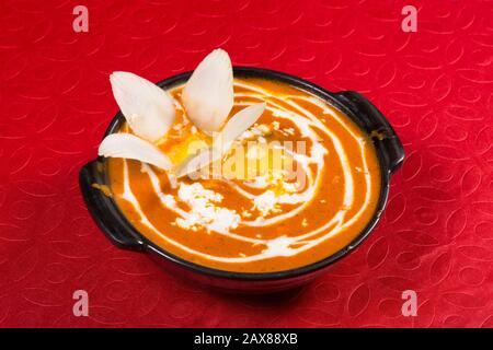 Leckere Tomaten-Süßkartoffel mit Linsensuppe in einer Schüssel auf dem Tisch Stockfoto