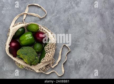 Draufsicht auf einen Saitensack mit Produkten auf grauem Betonhintergrund. Umweltkonzept keine Verschwendung mit Kopierraum Stockfoto