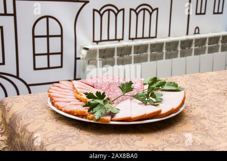 Fleisch und Wurst auf einem Teller auf einem Tisch Stockfoto