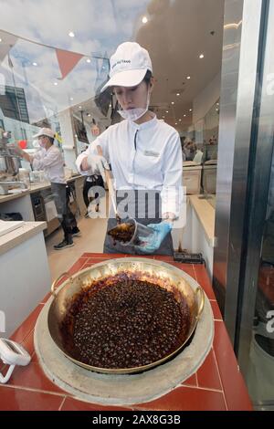 Ein junger Asian American macht im Xing Fu Tang, einem taiwanesischen Laden in Main St. in Flushing, Queens, New Yorks Chinatown, ein Boba-Milchgetränk im Fenster. Stockfoto