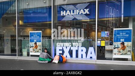 Ein männlicher Bettler sitzt außerhalb der Niederlassung der Halifax Building Society in Victoria Westminster, London, Großbritannien Stockfoto